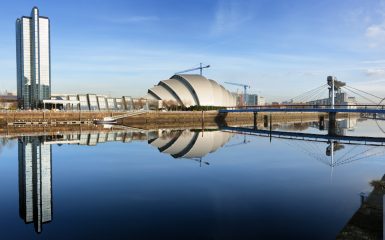 Landmarks on the River Clyde in Glasgow: the Crowne Plaza Hotel, the SECC Armadillo, the Bells Bridge, the Finnieston Crane, and the Clyde Arc.