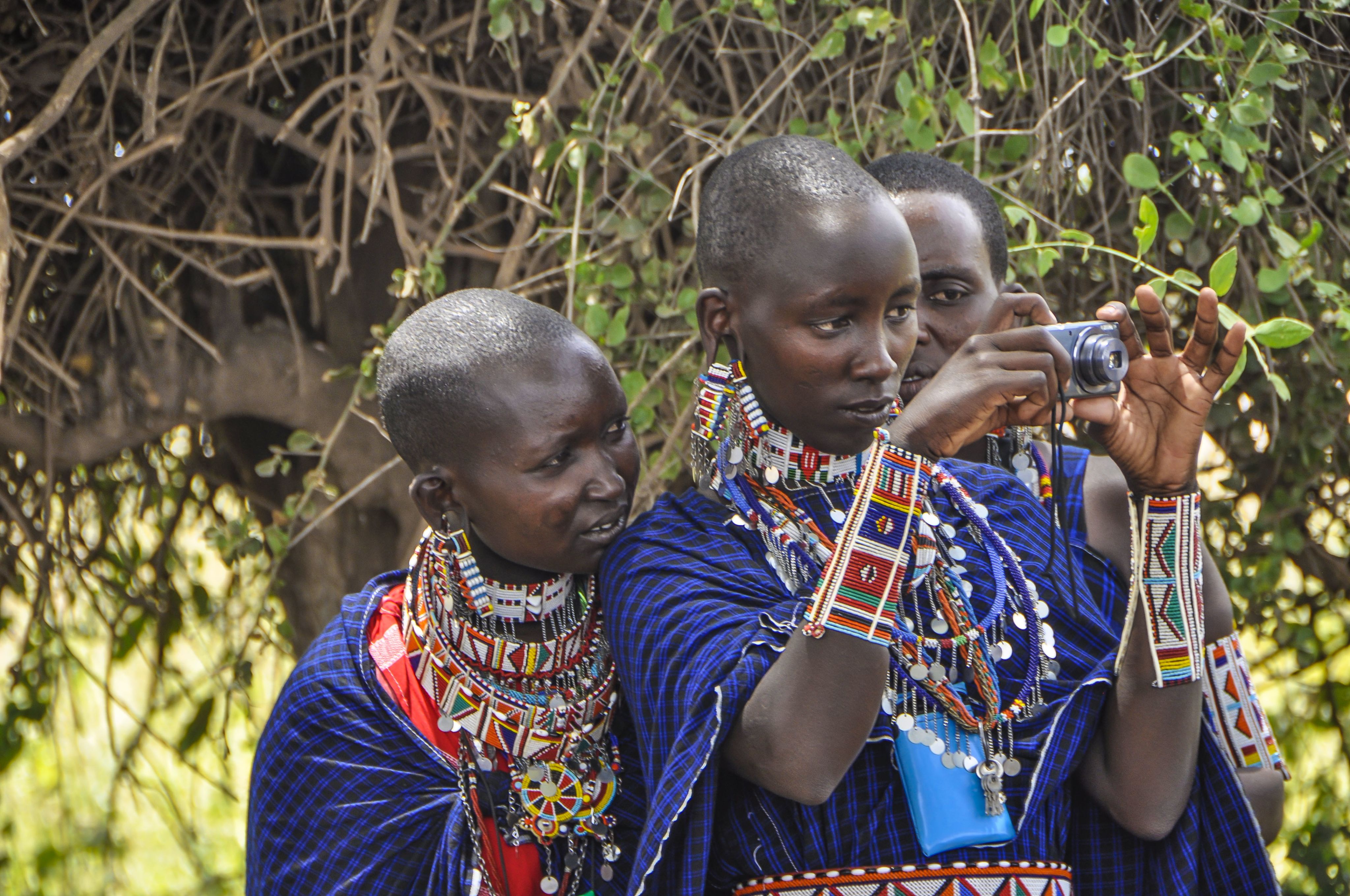 Kenyan women looking through the lens of a camera at an Envisioning Resilience workshop